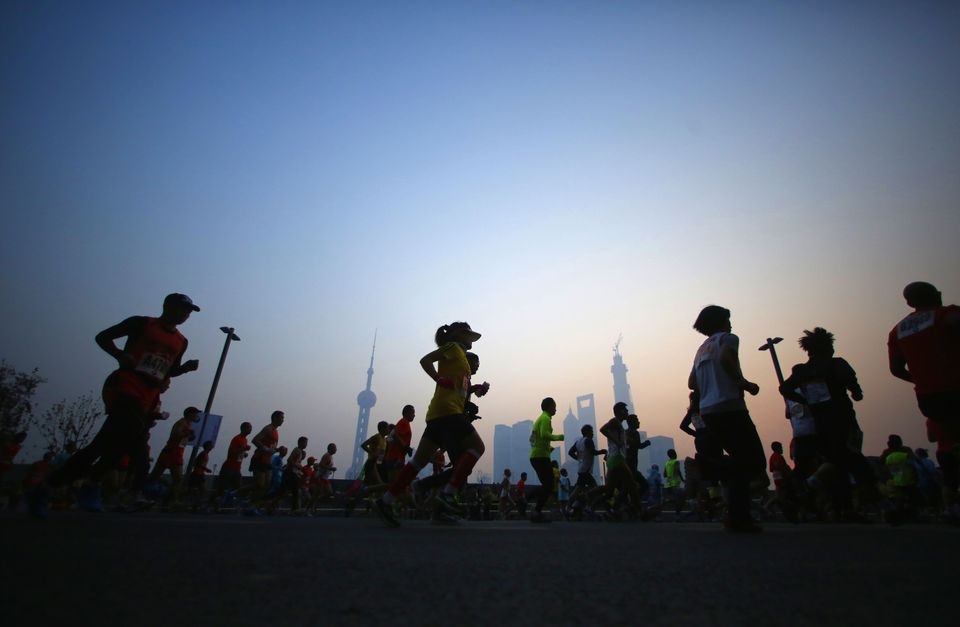Participants run on the Bund near Huangpu River as they compete in the Shanghai International Marathon December 1, 2013. REUTERS/Carlos Barria