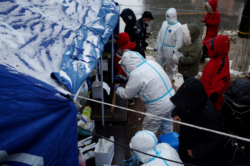 People line up for nucleic acid testing in the snow at a testing site in Jinpu New Area, following cases of the coronavirus disease (COVID-19) in Dalian, Liaoning province, China November 8, 2021. cnsphoto via REUTERS 