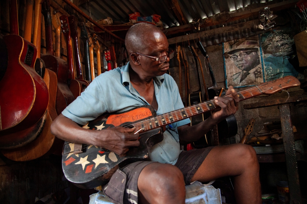 Guitar luthier Misoko Nzalayala Jean-Luther, alias Socklo, 61, plays one of the guitars he is repairing at his workshop in Kinshasa, Democratic Republic of Congo, October 18, 2021. REUTERS/Justin Makangara