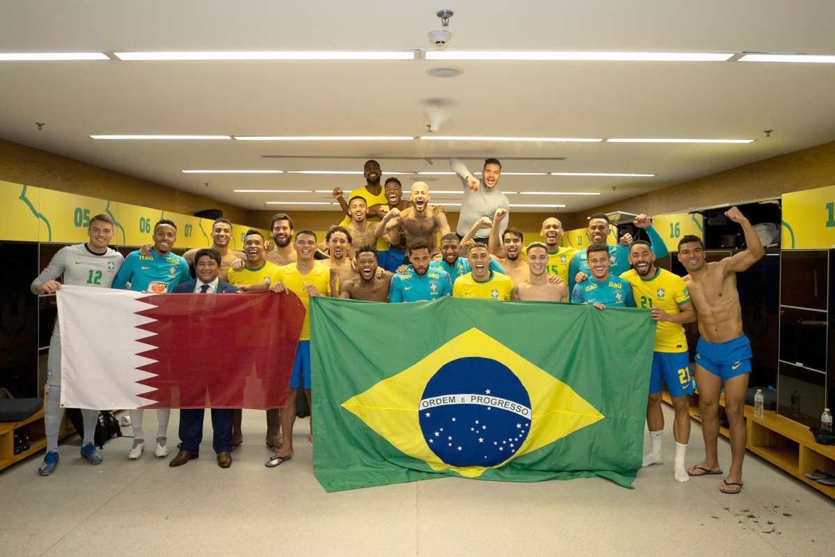 Brazil players and officials celebrate with Qatar and Brazil flags after qualifying for the 2022 FIFA World Cup following their 1-0 win over Colombia. Pic: Twitter/ @CBF_Futebol