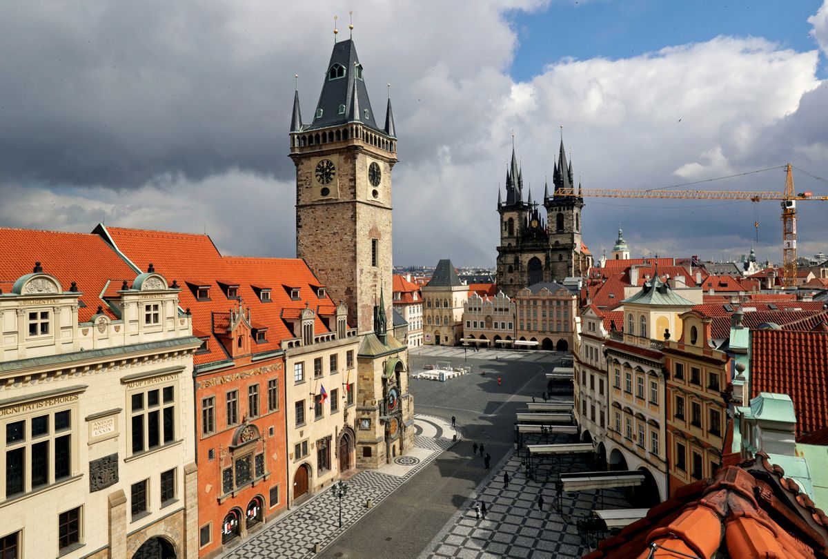 A clock showing the time at noon is pictured on a building, next to almost empty streets at Old Town Square during the coronavirus disease (COVID-19) outbreak, in Prague, Czech Republic, March 31, 2020. REUTERS/David W Cerny

