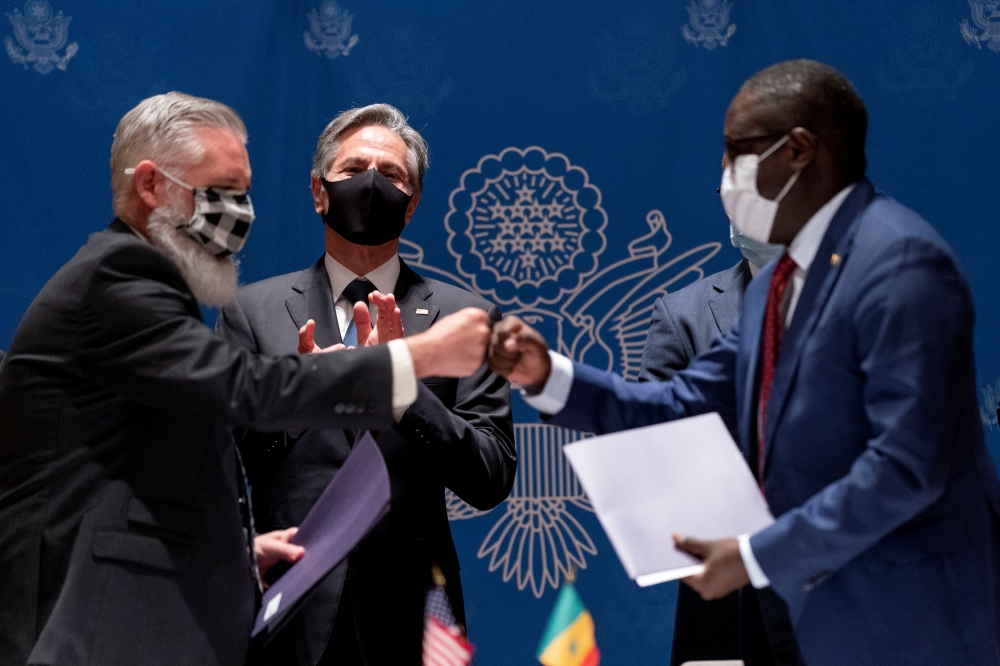 U.S. Secretary of State Antony Blinken, watches as Jeff Price, the Vice President and General Manager of Cubic Transportation Systems, fist bumps after signing an agreement during a commercial diplomacy event with U.S. companies and the Government of Senegal, at the Radisson Blu Hotel in Dakar, Senegal November 20, 2021. Andrew Harnik/Pool via REUTERS