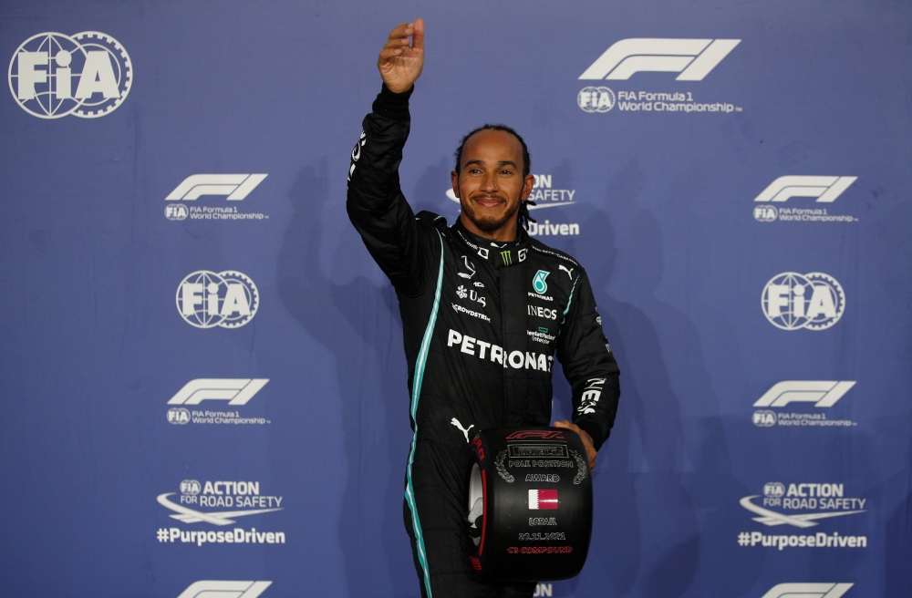Mercedes' Lewis Hamilton celebrates with the trophy on the podium after finishing first place in qualifying REUTERS/Hamad I Mohammed