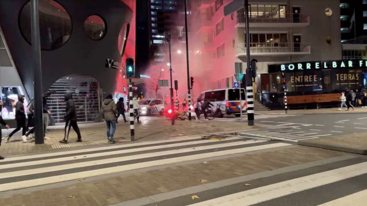 A protester throws a bicycle at a police vehicle in Rotterdam, Netherlands November 20, 2021, in this screen grab obtained from a social media video. Video recorded November 20, 2021. Sven Simcic - Video In Verzet via REUTERS