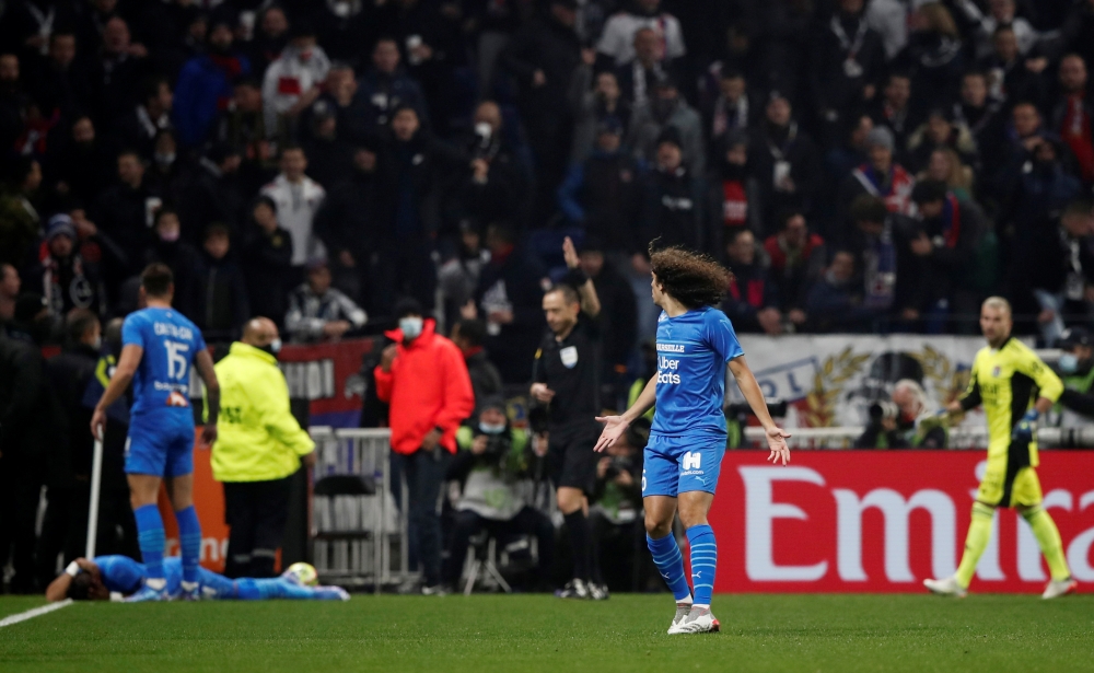 Olympique de Marseille's Matteo Guendouzi reacts after Dimitri Payet goes down after being hit by a water bottle thrown by a fan leading to the game being interrupted REUTERS/Benoit Tessier
