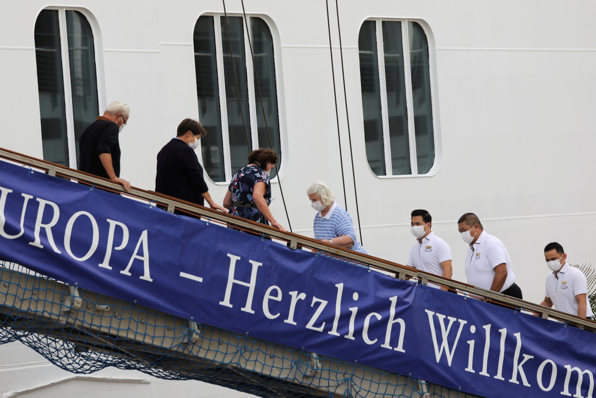 Passengers briefly disembark the MSC Europa cruise ship after docking to South African waters, as the new coronavirus variant Omicron spreads, in Cape Town, South Africa, November 30, 2021. REUTERS/Shelley Christians
