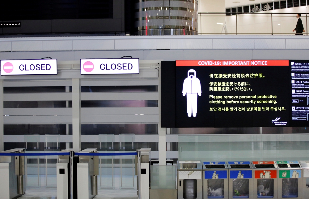 A notice about COVID-19 safety measures is pictured next to closed doors at a departure hall of Narita international airport on the first day of closed borders to prevent the spread of the new coronavirus Omicron variant in Narita, east of Tokyo, Japan, November 30, 2021. Reuters/Kim Kyung-Hoon/File Photo