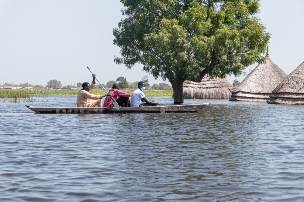 South Sudanese men navigate a canoe through flood waters in Bentiu in Unity State, South Sudan as seen in this image taken by Doctors Without Borders (MSF) on November 20, 2021. Picture taken November 20, 2021. Njiiri Karago/Medecins Sans Frontieres/Handout via REUTERS