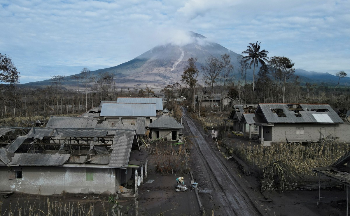 A local collects usable goods from her damaged house, at an area affected by the eruption of Mount Semeru volcano, in Curah Kobokan, Pronojiwo district, Lumajang, Indonesia, December 7, 2021. Picture taken with a drone. REUTERS/Willy Kurniawan TPX IMAGES OF THE DAY
