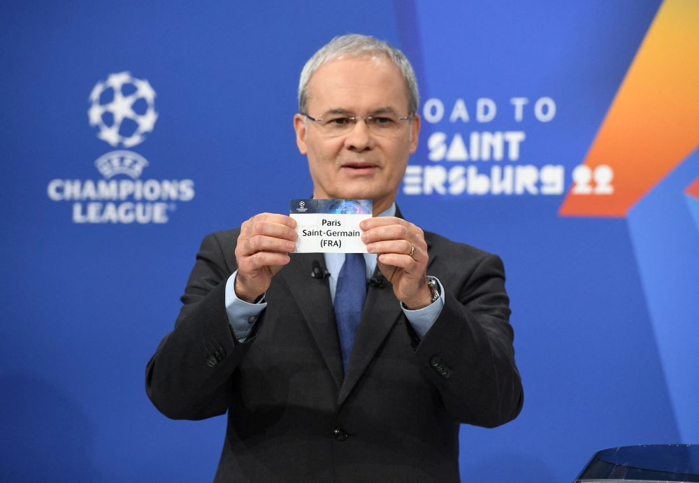 UEFA Deputy General Secretary Giorgio Marchetti draws out the card of Paris St Germain during the UEFA Champions League 2021/22 Round of 16 Draw at the UEFA headquarters (UEFA/Handout via REUTERS)