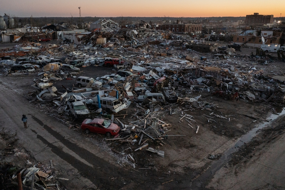 :A man walks past destroyed residences and businesses in the aftermath of a tornado in the city center of Mayfield, Kentucky, U.S. December 13, 2021. Picture taken with a drone. REUTERS/Adrees Latif
