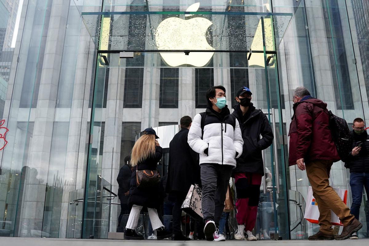 FILE PHOTO: People leave the Apple Store on Fifth Avenue on Black Friday in the Manhattan borough of New York City, New York, U.S., November 26, 2021. REUTERS/Carlo Allegri/File Photo
