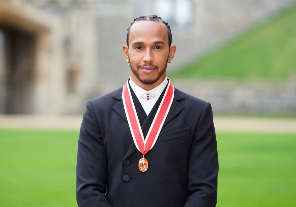 Lewis Hamilton poses for a photo after he was made a Knight Bachelor by Britain's Charles, Prince of Wales, during an investiture ceremony at Windsor Castle in Windsor, Britain, December 15, 2021. Andrew Matthews/Pool via REUTERS
