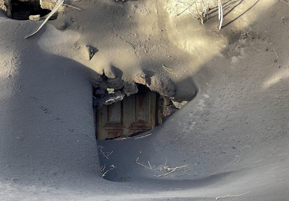 A house near the Tacande neighbourhood is surrounded by ash of the Cumbre Vieja volcano, on the Canary Island of La Palma, Spain, December 15, 2021. REUTERS/Marco Trujillo 