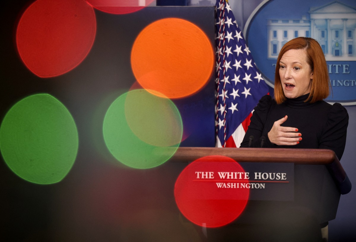 Press Secretary Jen Psaki is seen through Christmas lights during a media briefing at the White House in Washington, U.S., December 23, 2021. REUTERS/Evelyn Hockstein
