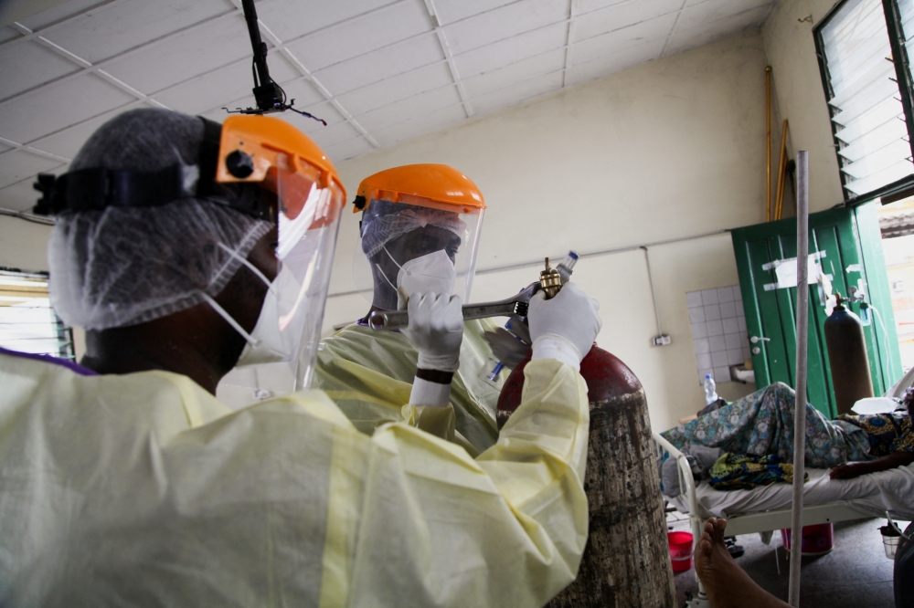 Health workers wearing protective gear prepare an old tank containing oxygen, at the St. Joseph Covid-19 treatment centre in Kinshasa, Democratic Republic of Congo, December 24, 2021. Reuters/Justin Makangara