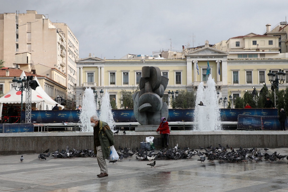 A man wearing a protective face mask makes his way amid the coronavirus disease (COVID-19) outbreak, in Athens, Greece, December 29, 2021. REUTERS/Louiza Vradi
