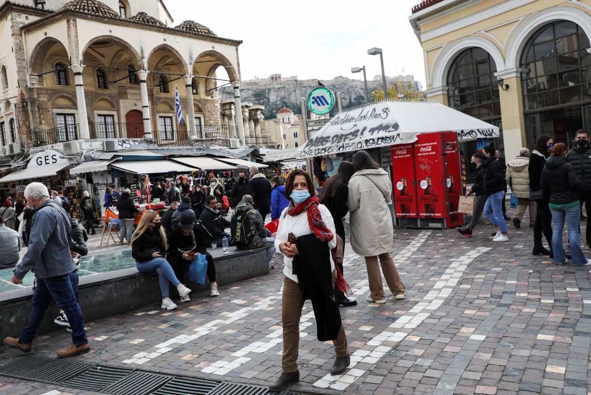 People wearing protective face masks make their way to Monastiraki square amid the coronavirus disease (COVID-19) outbreak, in Athens, Greece, December 29, 2021. REUTERS/Louiza Vradi
