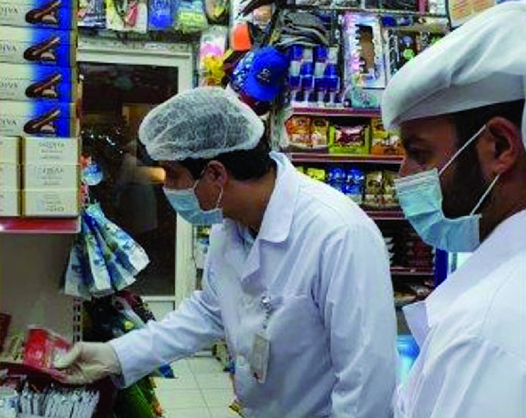 Officials conducting inspections in a shop.