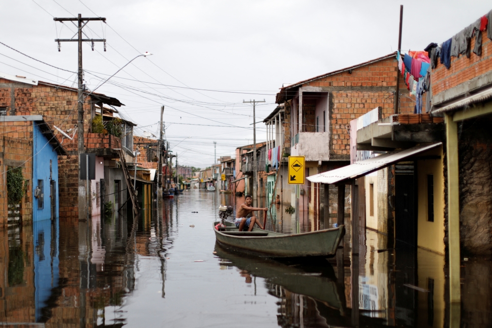 A man uses a canoe to visit his flooded house during floods caused by heavy rain in Maraba, Para state, Brazil January 9, 2022. REUTERS/Ueslei Marcelino
