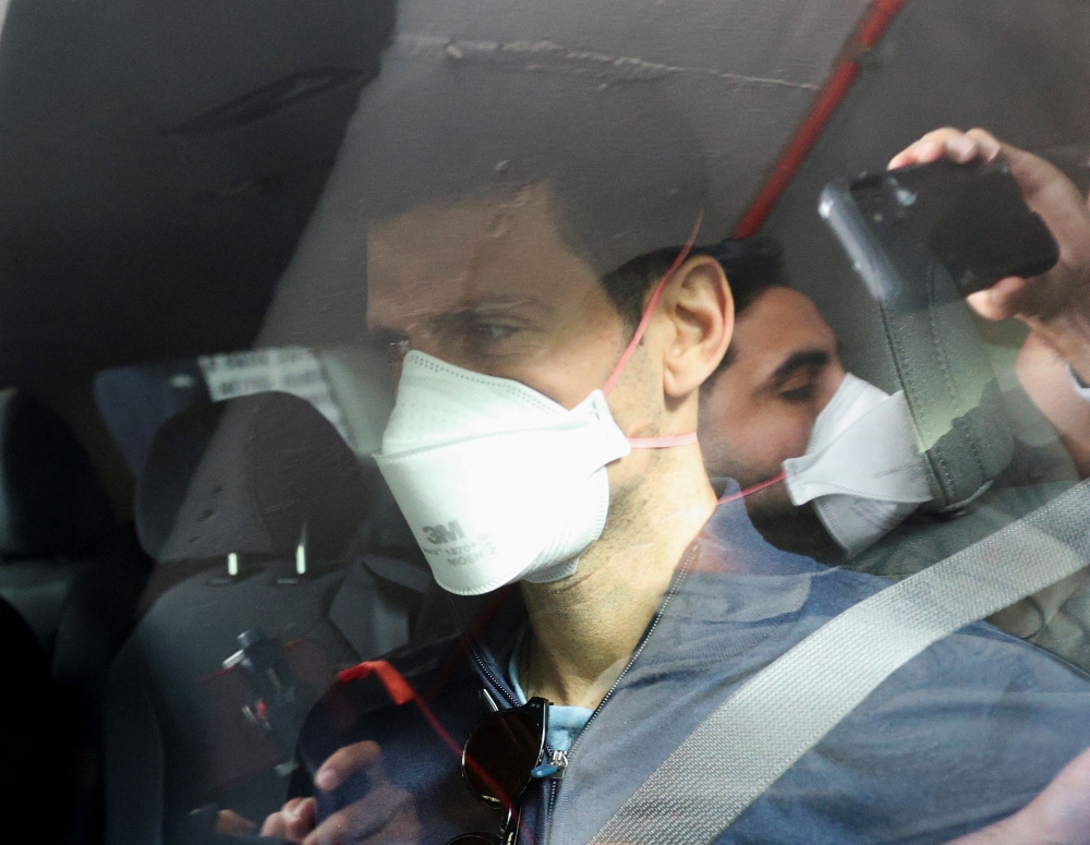Serbian tennis player Novak Djokovic departs the Park Hotel while under immigration detention, to convene with his legal team after his visa to play in the Australian Open was cancelled a second time, in Melbourne, Australia, January 16, 2022. REUTERS/Loren Elliott
 