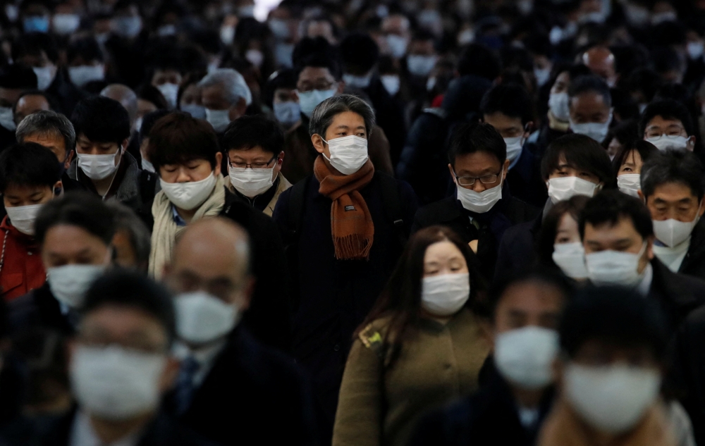 Commuters wearing protective face masks, amid the coronavirus disease (COVID-19) pandemic, make their way at a train station in Tokyo, Japan, January 17 2022. REUTERS/Kim Kyung-Hoon