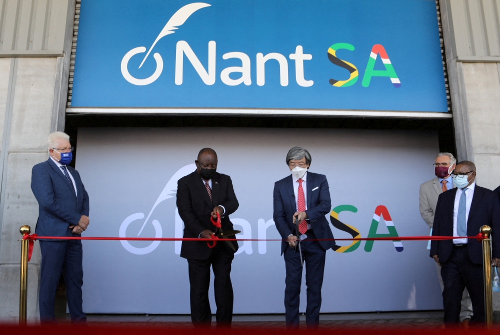 South African President Cyril Ramaphosa and Dr. Patrick Soon-Shiong cut a ribbon, while Premier of the Western Cape Alan Winde looks on, during the launch of NantSA, a future vaccine manufacturing facility designed to accelerate the production of pharmaceuticals, in Cape Town, South Africa, January 19, 2022. REUTERS/Shelley Christians
 