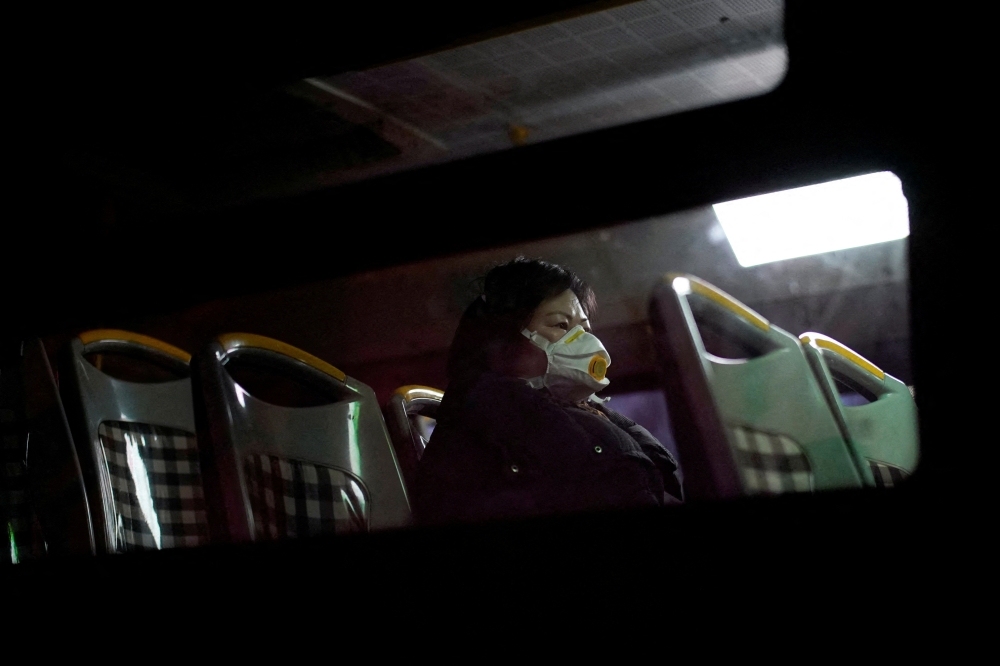 A woman wearing a protective face mask sits on a bus, following new cases of the coronavirus disease (COVID-19), in Shanghai, China January 20, 2022. REUTERS/Aly Song/File Photo
