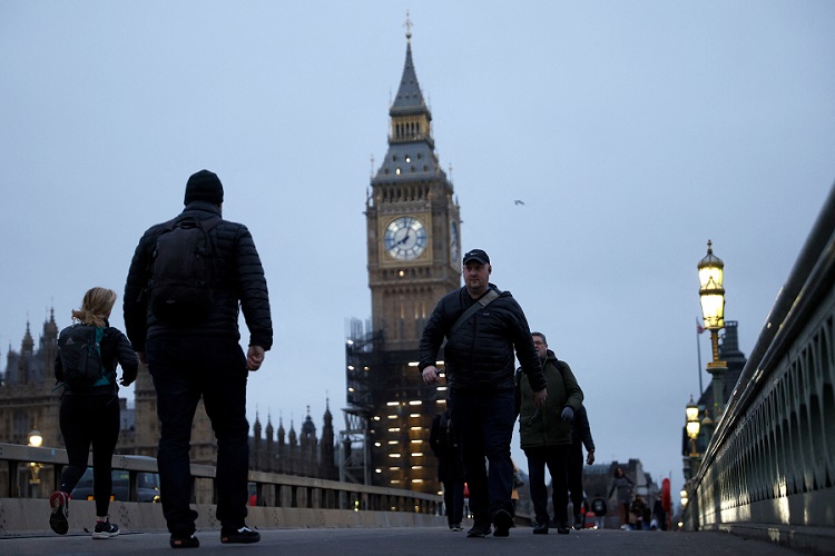People walk over Westminster Bridge during morning rush hour, amid the ongoing coronavirus disease (COVID-19) pandemic in London, Britain, January 27, 2022. REUTERS/John Sibley
