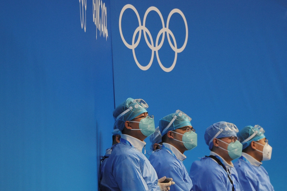 Medical personnel wearing personal protective equipment (PPE) sit rink-side at the Wukesong Arena for ice hockey games ahead of the Beijing 2022 Winter Olympics in Beijing, China, January 30, 2022. REUTERS/Brian Snyder