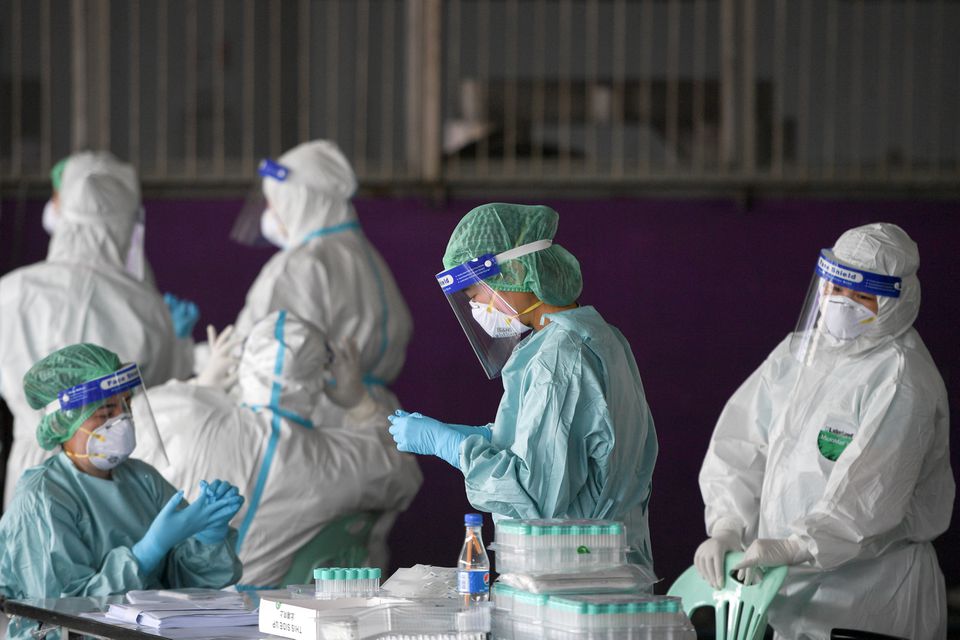 FILE PHOTO: Healthcare workers get ready to collect samples during proactive testing of migrant workers at their work place, amid the spread of the coronavirus disease (COVID-19) outbreak in Samut Sakhon province in Thailand, January 27, 2021. REUTERS/Chalinee Thirasupa

