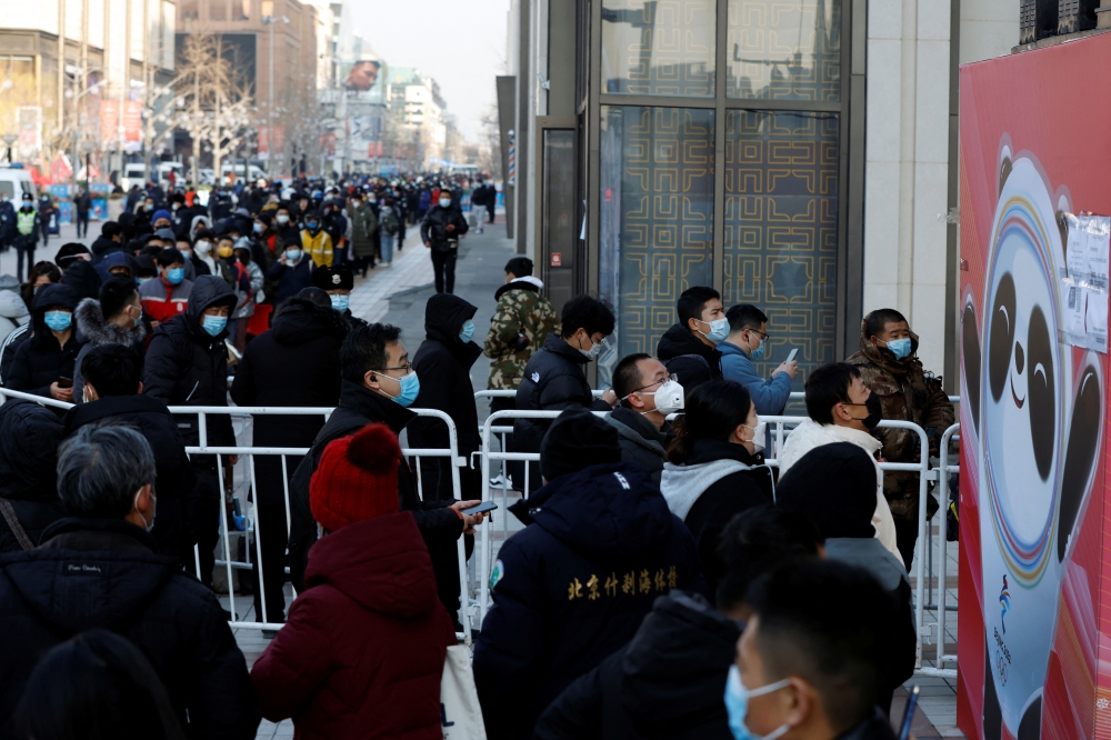 People wearing face masks wait in line to enter a flagship merchandise store for the Beijing 2022 Winter Olympics on Wangfujing street in Beijing, China. Reuters/Carlos Garcia Rawlins