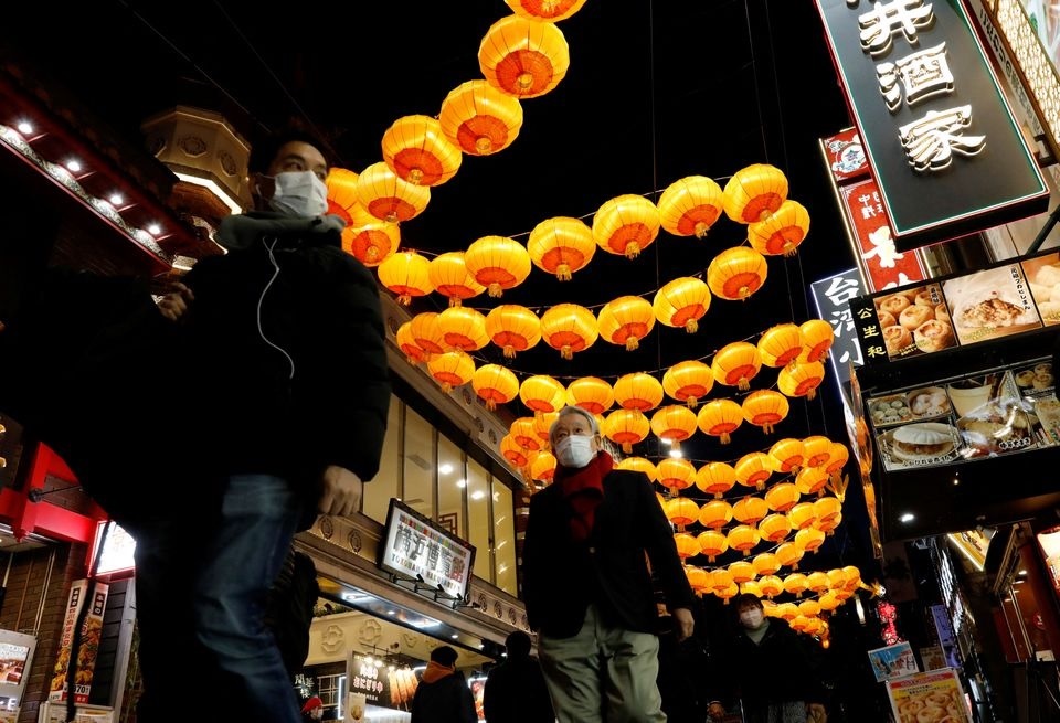People wearing protective masks, amid the coronavirus disease (COVID-19) outbreak, walk past lantern decoration on Lunar New Year's Eve at China town in Yokohama, Kanagawa Prefecture, Japan, January 31, 2022. REUTERS/Kim Kyung-Hoon
