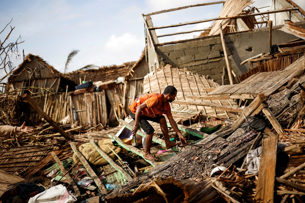 A man works on the destroyed house of Philibert Jean Claude Razananoro, in the aftermath of Cyclone Batsirai, in the town of Mananjary, Madagascar, February 8, 2022. REUTERS/Alkis Konstantinidis/File Photo