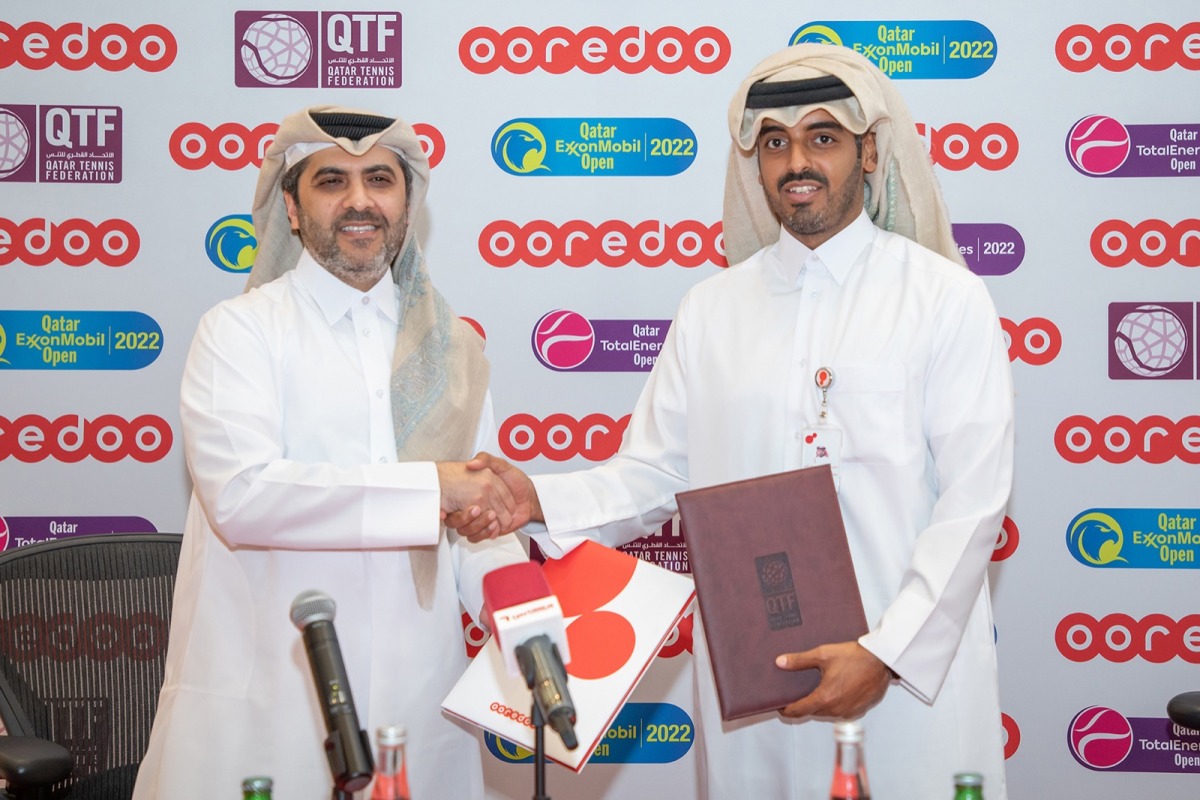 Sheikh Nasser bin Hamad bin Nasser Al Thani, Chief Commercial Officer at Ooredoo, and Tariq Zainal, Qatar Tennis, Squash and Badminton Federation's General Secretary, exchange documents during the sponsorship signing ceremony.