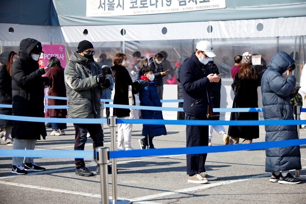 People wait in line to undergo the coronavirus disease (COVID-19) test at a temporary testing site set up in Seoul, South Korea, February 16, 2022. REUTERS/ Heo Ran