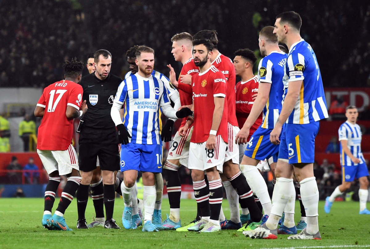 Players surround referee Peter Bankes as he initially gives Brighton & Hove Albion's Lewis Dunk a yellow card before changing it to a red card after looking at the VAR monitor REUTERS/Peter Powell 