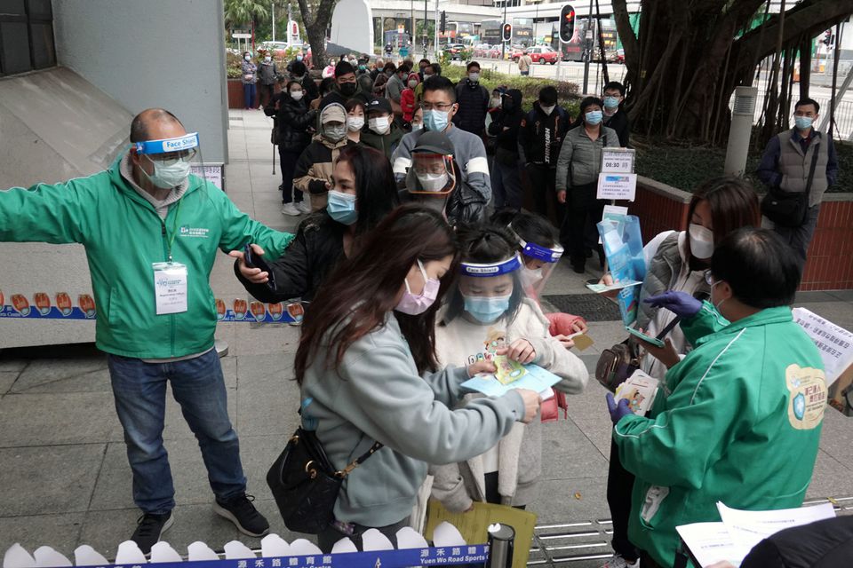Staff members attend to residents lining up to receive the Sinovac Biotech vaccine against the coronavirus disease (COVID-19), at a community vaccination centre in Sha Tin district of Hong Kong, China February 18, 2022. REUTERS/Joyce Zhou


