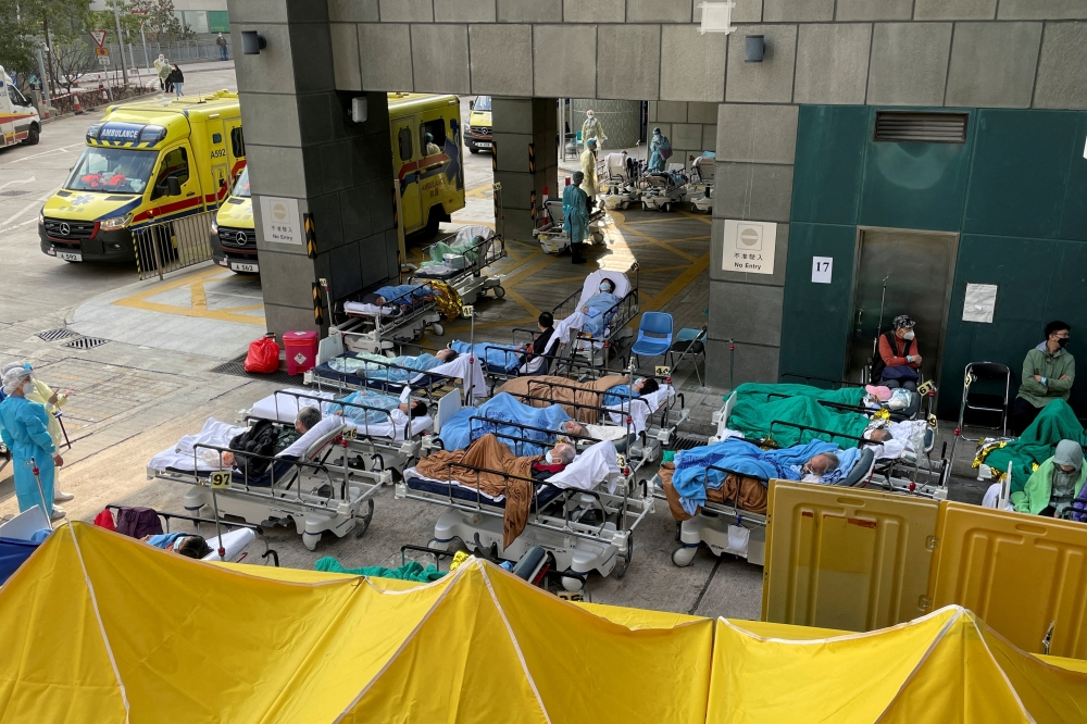 Patients wearing face masks lie in bed at a makeshift treatment area outside a hospital, following the Covid-19 outbreak in Hong Kong, China February 16, 2022. Reuters/Aleksander Solum/File Photo