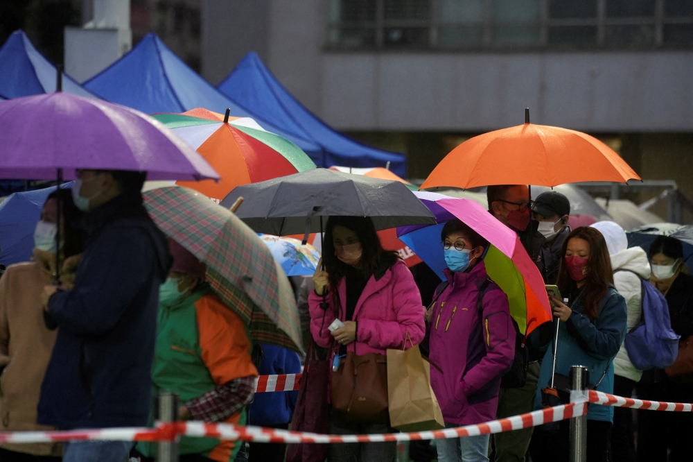 People queue in the rain at a makeshift testing centre for the coronavirus disease (COVID-19) in Hong Kong, China February 20, 2022. REUTERS/Lam Yik