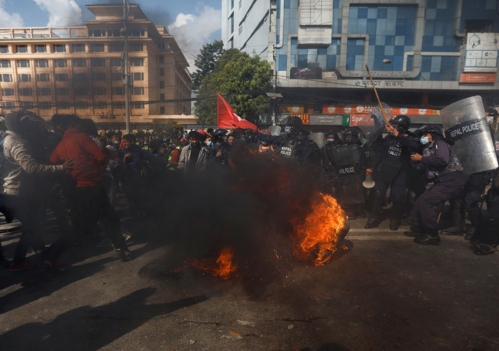 A demonstrator throws a burning tire towards the riot police during a protest against the $500 million U.S infrastructure grant under the Millennium Challenge Corporation (MCC) near the parliament in Kathmandu, Nepal February 20, 2022. REUTERS/Navesh Chitrakar