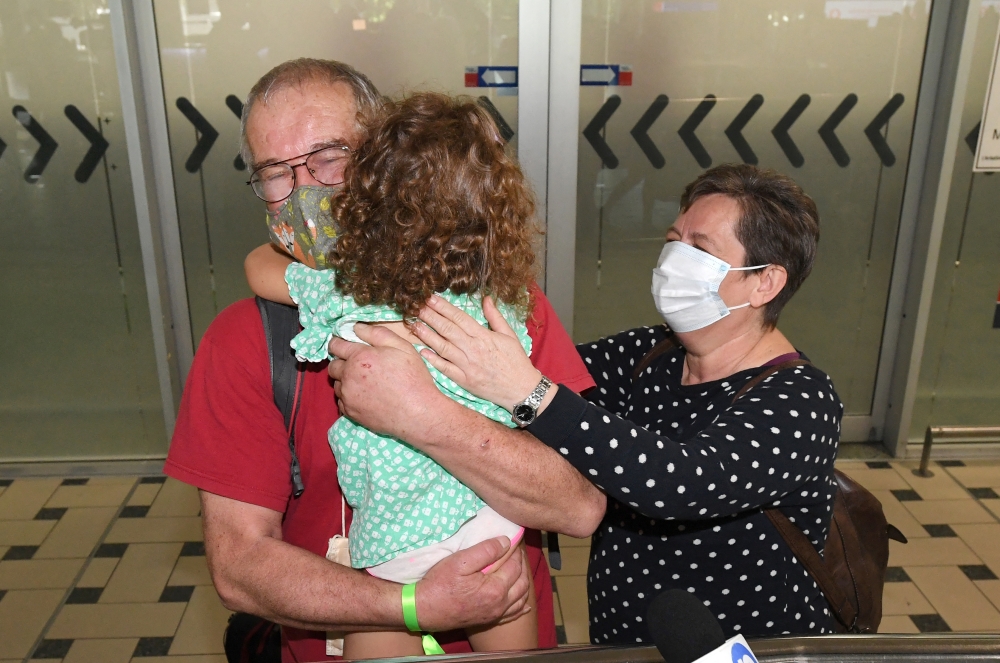 Rudolf and Julianna Nemeth from Hungary reunite with their granddaughter Lili as they arrive on the first international flight to the Brisbane International Airport, Australia February 21, 2022. AAP Image/Darren England via Reuters