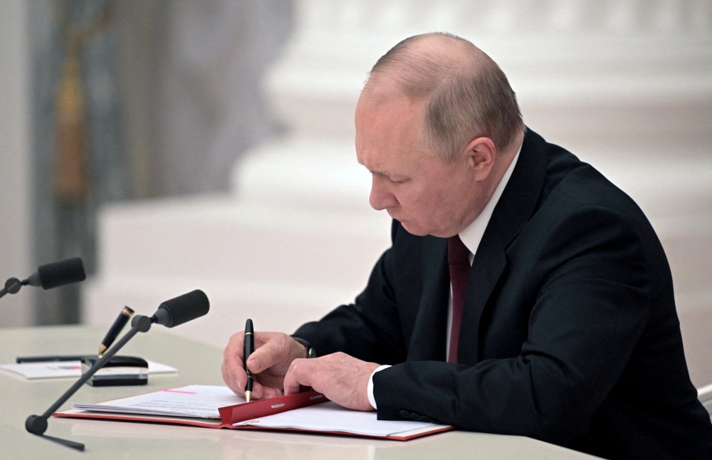 Russian President Vladimir Putin signs documents, including a decree recognising two Russian-backed breakaway regions in eastern Ukraine as independent entities, during a ceremony in Moscow, Russia, in this picture released February 21, 2022. Sputnik/Alexey Nikolsky/Kremlin via Reuters