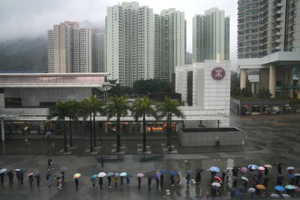 People line up for a nucleic acid test at a makeshift testing site set up next to a mobile testing vehicle dispatched from mainland China in Tung Chung, Hong Kong, China February 21, 2022. Reuters/Lam Yik