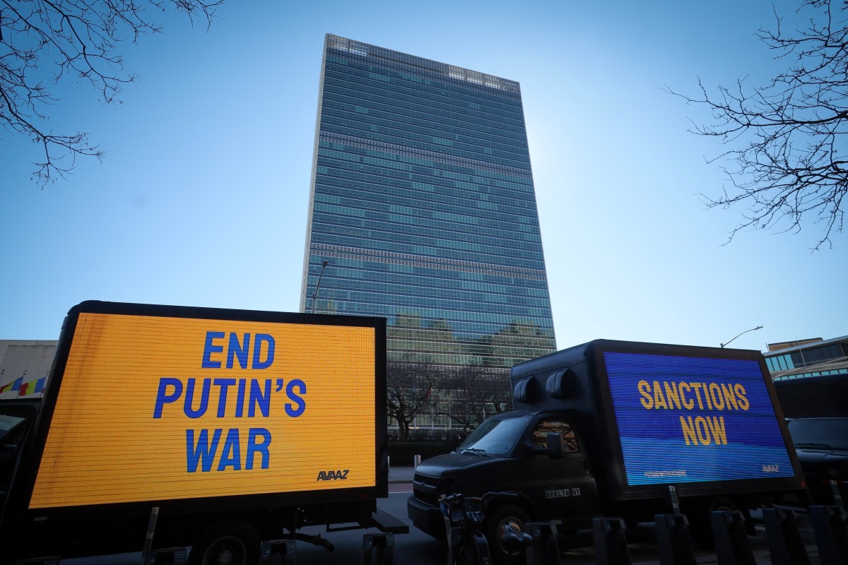 Trucks display electronic messages while protestors demonstrate outside United Nations headquarters, as inside diplomats hold an emergency session of the 193-member U.N. General Assembly on Russia's invasion of Ukraine, in Manhattan in New York City, New York, U.S., February 28, 2022. REUTERS/Mike Segar
