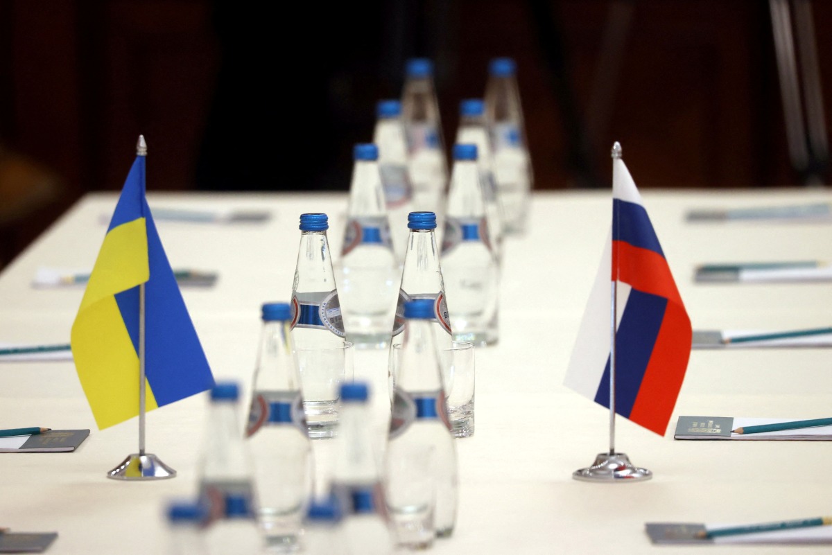 FILE PHOTO: Russian and Ukrainian flags are seen on a table before the talks between officials of the two countries in the Gomel region, Belarus February 28, 2022. Sergei Kholodilin/BelTA/Handout via REUTERS

