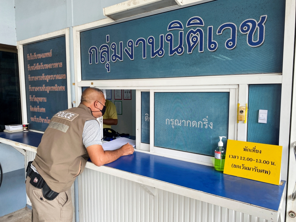 A local Thai police personnel picks up the autopsy result of Australian cricketer Shane Warne, ahead of a news conference following his death, at a hospital in Surat Thani province, Thailand, March 7, 2022. REUTERS/Jiraporn Kuhakan