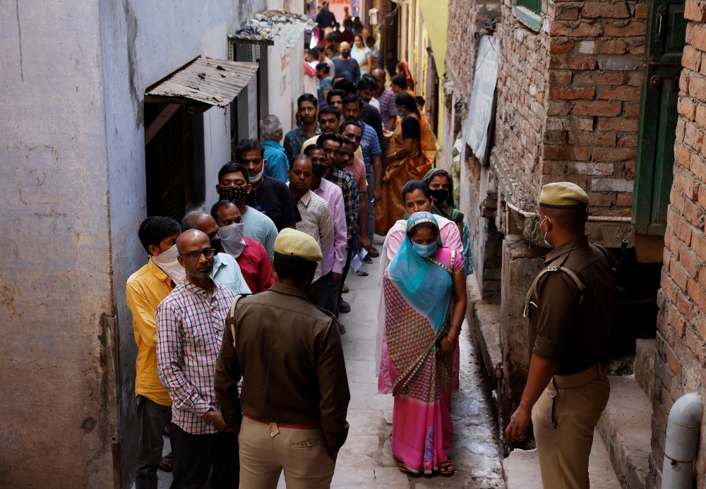 People stand in a queue to cast their votes at a polling station during the last phase of state assembly election in Varanasi in the northern state of Uttar Pradesh, India, March 7, 2022. Reuters/Adnan Abidi