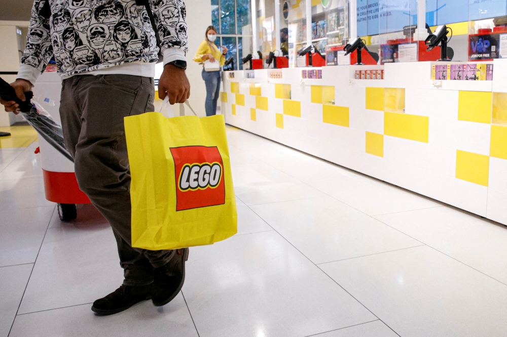 A customer carries a bag while shopping in the 5th Avenue Lego store in New York City, U.S., September 28, 2021. REUTERS/Brendan McDermid/File Photo/File Photo