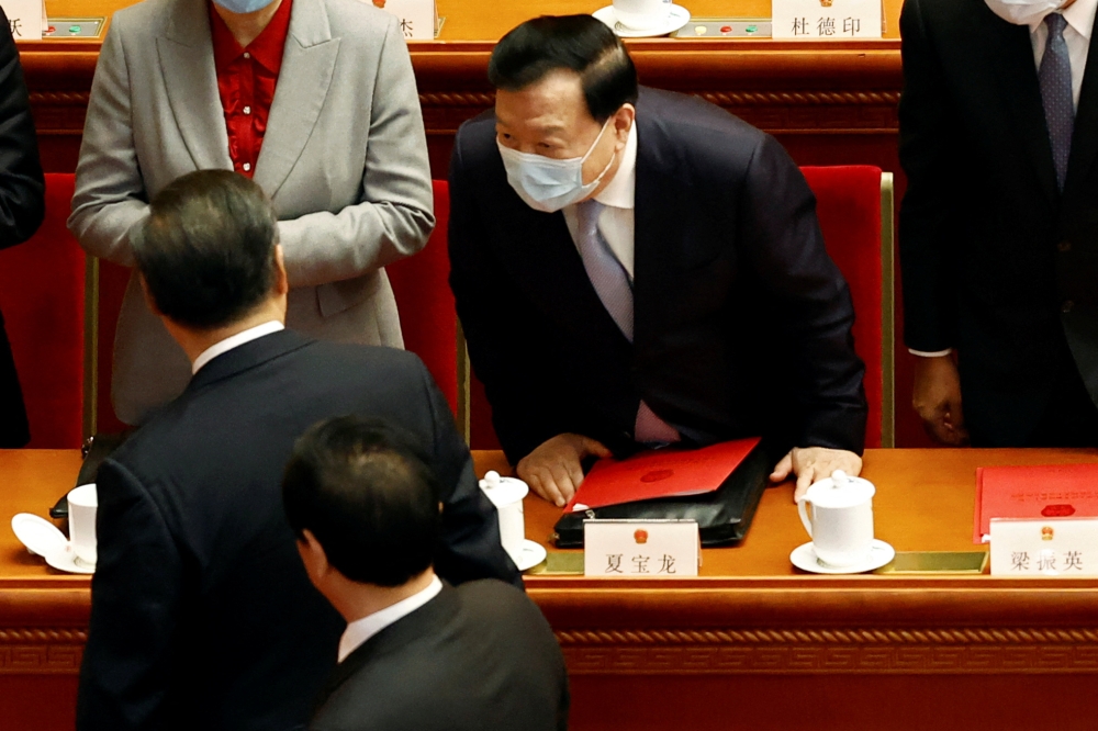 Xia Baolong, director of the Hong Kong and Macau Affairs Office, interacts with Chinese President Xi Jinping at the end of the closing session of the National People's Congress (NPC) at the Great Hall of the People in Beijing, China March 11, 2022. Reuters/Carlos Garcia Rawlins